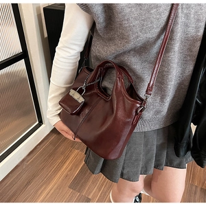 Dettaglio borsa tote bordeaux con trama in PU lucido e portamonete con catena rimovibile