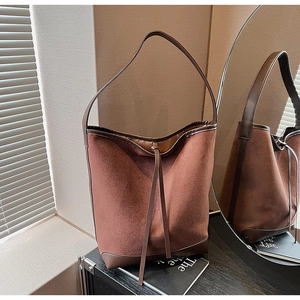 Detail of the suede and smooth leather stitching texture on this brown bucket bag
