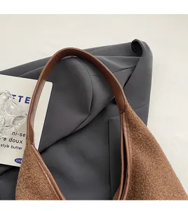 Detail of soft brown fleece shoulder bag featuring wide leather straps and zipper closure