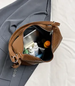Detalle del interior del bolso de hombro marrón que muestra su gran capacidad de almacenamiento