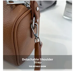 Macro detail of brown lychee texture leather cylinder bag with silver metal clip