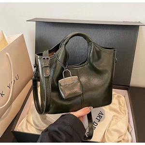 Dettaglio borsa tote in pelle verde scuro lucida con catena argento e mini pochette