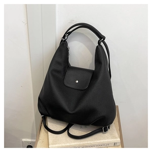 Detalle de la mochila negra con textura plisada vertical y cierre magnético de plata