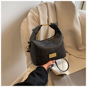 Detail of vintage textured handbag with round handle and gold LADY COLLECTION metal plaque
