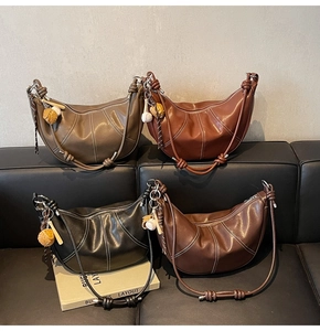 Detail of croissant bags in four colors with contrast stitching and knot straps