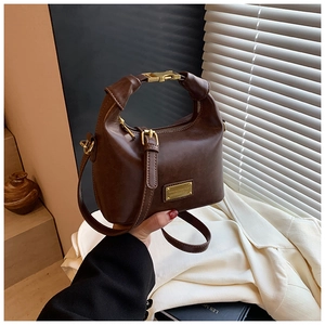 Detailed view of deep brown vintage handbag with gold hardware and matte finish