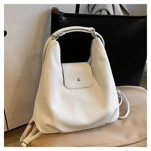 Detalle de bolso de pana blanco con solapa magnética y correa ajustable para hombro
