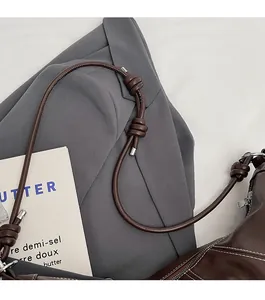 Detail view of the knotted brown leather shoulder strap with silver metal end caps