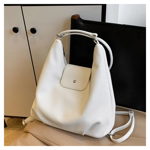 Detalle de la textura de pana blanca y hebilla de metal plateado en el bolso hobo
