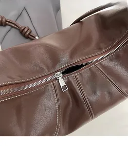 Detailed macro shot of smooth silver metal zipper and white contrast stitching on leather