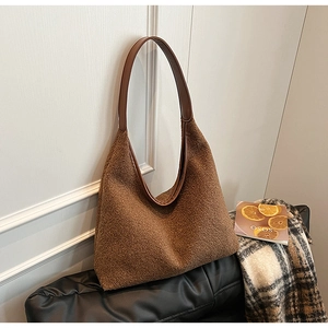 Detail of brown faux shearling shoulder bag with leather strap and soft autumn texture
