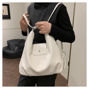 Primer plano de mochila de pana blanca con textura plisada y detalle de hebilla metálica