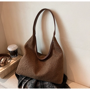 Detail of brown wool tote bag with leather strap and warm minimalist seasonal styling