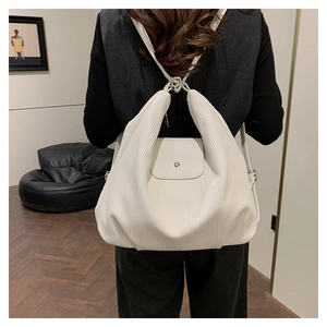 Detalle de la textura plisada blanco roto y correas ajustables de la mochila