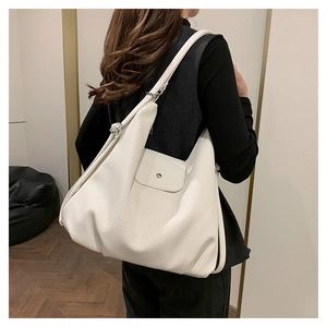 Vista lateral del bolso Hobo blanco plisado que muestra su gran capacidad y caída suave