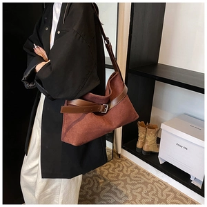 Détail du cabas en cuir givré bordeaux avec lanière marron et boucle métallique