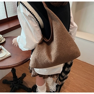 Detailed view of brown plush tote bag with smooth leather strap for autumn fashion