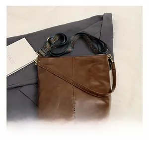 Detail view of brown leather tote bag with jacquard and leather interchangeable straps