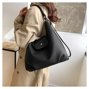 Detalle del bolso tote negro plisado con textura de PU y cierre magnético de metal