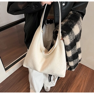 Close-up of a large beige faux fur tote bag with a soft fuzzy texture and leather strap