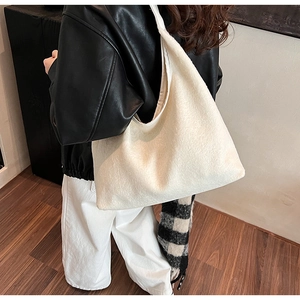 Woman wearing a large cream faux fur tote bag showing the side view for autumn outfits