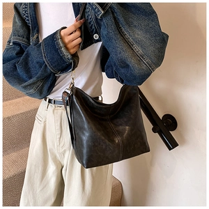 Detail view of large leather hobo bag with ethnic style wide strap and golden clasp