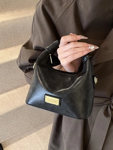 Classic black glossy faux leather crescent handbag with elegant gold hardware for women