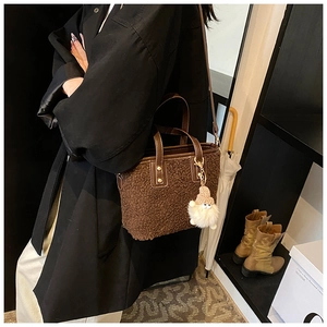 Brown faux fur bucket bag with leather handles and cute plush dwarf doll charm