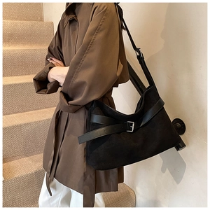 Détail d'un grand sac cabas en daim noir mat avec lanières en cuir et boucles argentées