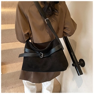 Détail d'un grand sac cabas vintage noir mat avec bandoulière en cuir et boucle décorative