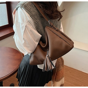 Detail der dunkelbraunen Hobo-Tasche mit Faltenstruktur und schickem Quastenanhänger