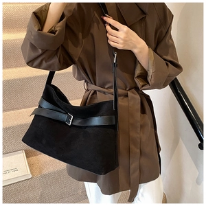 Detail of vintage matte suede tote bag with leather buckle strap and minimalist design