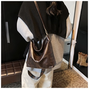 Detail of dark brown retro hobo bag with vintage texture and jacquard strap