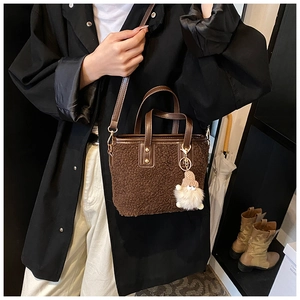 Brown lamb wool plush bucket bag with cute knit doll charm and leather strap detail