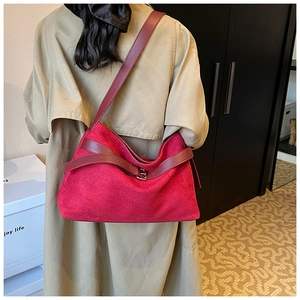 Macro shot of burgundy faux suede tote with leather strap and decorative buckle detail