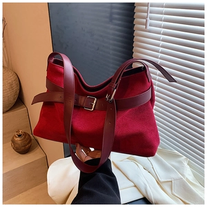 Vue détaillée du sac cabas en daim rouge foncé avec boucle en cuir et bandoulière