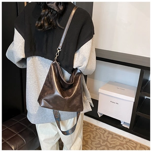 Detail of dark brown oil wax leather tote bag with ethnic pattern wide strap