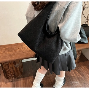 Detail of soft black woolen tote bag showing textured fabric and spacious interior design