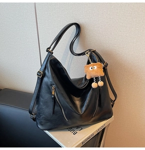 Detail of black leather backpack with decorative zippers and a cute star charm