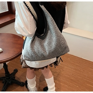 Detail of grey wool tote bag with black leather strap for autumn commuter style