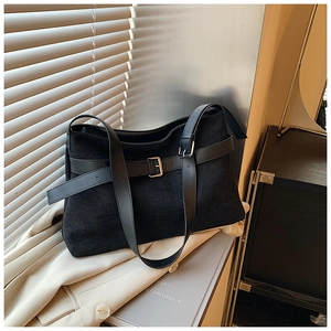 Détail du sac cabas en daim noir avec boucles décoratives et jeux d'ombres élégants