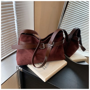 Vue détaillée du sac en daim bordeaux avec bandoulière en cuir marron et boucle argent