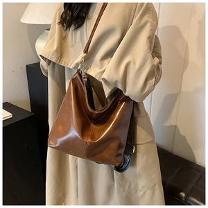 Detail view of brown vintage bucket bag with ethnic patterned wide shoulder strap
