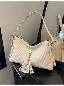 Minimalist beige pleated faux leather crossbody bag with fringe tassel detail and strap