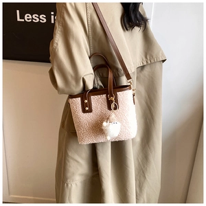 Detail of fuzzy faux shearling mini bucket bag with leather trim and plush charm