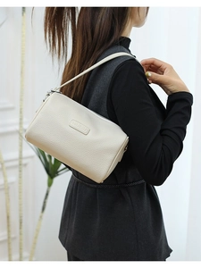White lychee pattern leather barrel bag with slim shoulder strap shown on model