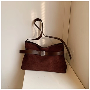 Gros plan sur la texture en daim mat avec sangles en cuir foncé et boucle argentée