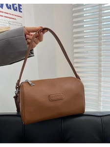 Brown leather cylinder shoulder bag with GubiDili logo and adjustable strap for women