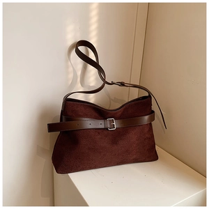 Détail du fourre-tout vintage en daim marron avec boucle argentée et texture mate