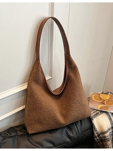 Brown fleece tote bag with leather handles shown in a lifestyle cozy setting